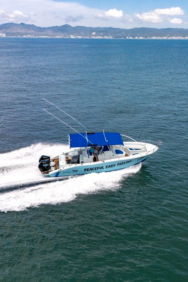 Twin 300 HP Mercury outboards pushing Peaceful Easy Feeling across the bay