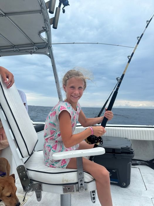 Young angler working a rod on a family charter